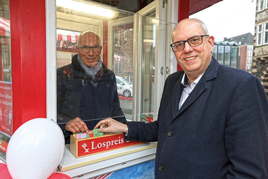 Bremens Bürgermeister Dr. Andreas Bovenschulte kauft Lose auf der Bürgerpark-Tombola